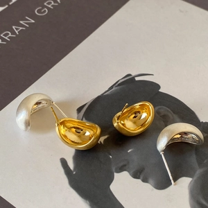 Minimalist irregular crescent stud earrings in polished gold and matte silver metal finish