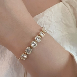 Vue détaillée d'un bracelet doré élégant avec zircons carrés porté au poignet