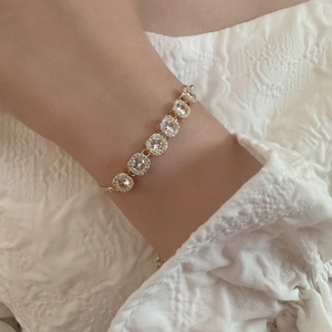 Détail d'un bracelet doré de luxe avec sept zircons carrés portés sur le poignet