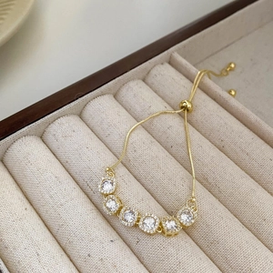 Gros plan d'un bracelet doré avec oxydes de zirconium et fermoir coulissant réglable