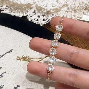 Bracelet doré ajustable orné de six oxydes de zirconium carrés au design minimaliste