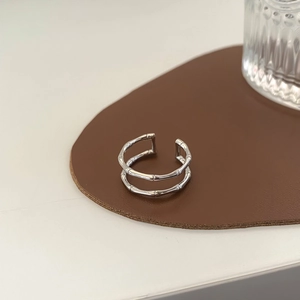 Detail of silver double-layer bamboo joint ring on a premium brown leather texture pad