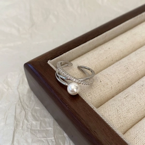Détail de la bague croisée en argent avec perle et zircons dans un écrin à bijoux
