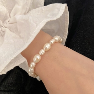 Bracelet élastique en perles d'eau douce baroques vintage sur un poignet femme