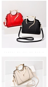 Detail of stylish handbag with cat-ear metal handles and contrast stitching