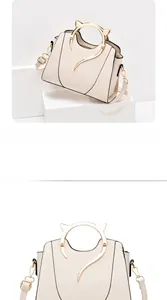 Detailed close-up of cream white handbag featuring golden cat-ear metal handles
