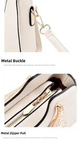 Detailed close-up of light gold metal hooks and smooth zippers on white leather handbag