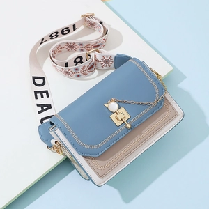 Minimalist color-block crossbody bag with cat-shaped lock and wide striped shoulder strap