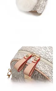 Detail of PU leather backpack featuring letter prints, dual zippers and white pompom charm