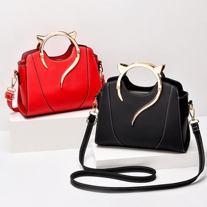 Fashionable PU leather handbag for women featuring unique golden cat-ear metal handles