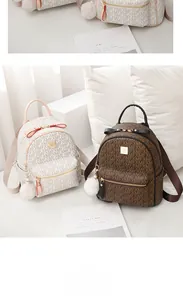 Detail of elegant beige and brown mini backpacks with MFX monogram and fuzzy charms