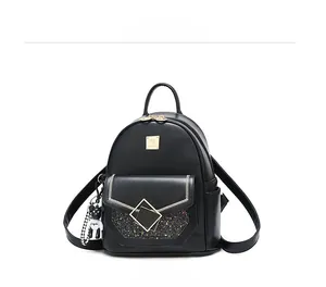 Close-up of black PU leather backpack with sequined detail and cute bear keychain