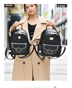 Comparison of small and large black leather backpacks with gold metal buckles and charms