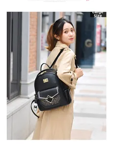 Detail of black faux leather backpack featuring golden zippers and sequins on city street