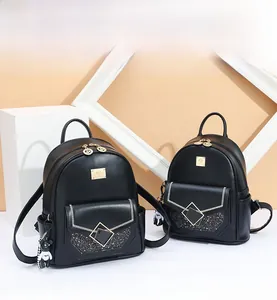 Detail of black PU leather backpack with gold hardware and glitter diamond buckle