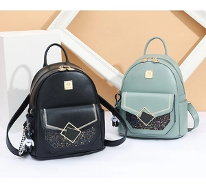 Detail of mini leather backpacks in black and green with glitter and bear charms