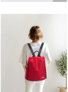 Sac à dos rouge en nylon pour femme avec bretelles noires porté par un mannequin de dos