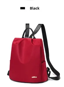 Détail d'un sac à dos rouge en nylon imperméable avec logo doré et poignée noire