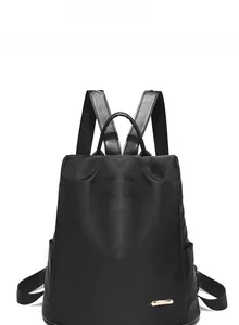 Détail frontal du sac à dos oxford noir imperméable avec plaque logo en métal doré