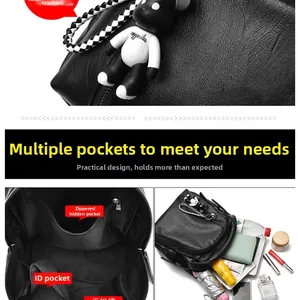 Detail view of the black pebble leather backpack with multi-pocket interior and bear charm