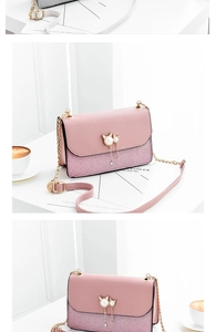 Detailed view of pink chain bag featuring pearl cat buckle and tassel decoration