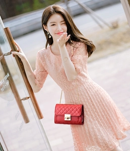 Elegant red quilted leather crossbody bag with gold chain strap on female model