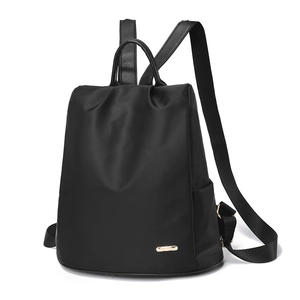 Sac à dos noir classique en nylon imperméable pour femme avec logo doré et poignées en cuir