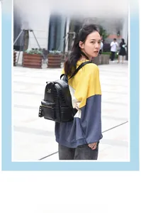 Outdoor shot of a black crocodile pattern mini backpack worn by a female model