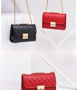 Close-up of quilted pattern and gold metal chain on chic red and black handbags
