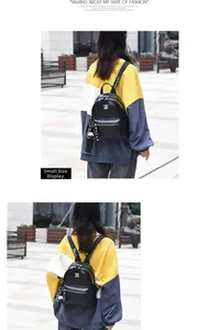 Detail of a small black crocodile texture backpack with gold hardware and bear charm