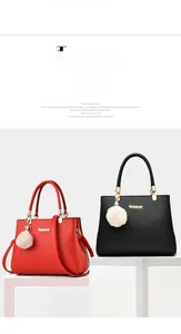 Detail of red and black matte leather handbags with gold hardware and plush charm