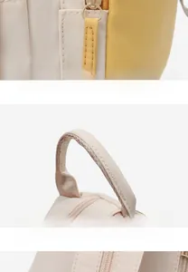 Detail of premium golden zippers and reinforced top handles on a two-tone oxford backpack