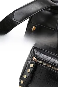 Detail of reinforced straps and gold rivets on a black crocodile pattern backpack