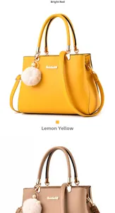Detail of leather handbags with plush ball charms and gold-tone metal hardware