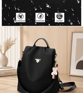 Detalle de la tela oxford impermeable y el logo metálico de la mochila negra
