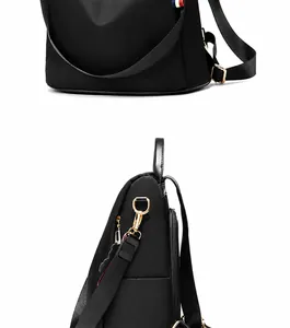 Detalle de mochila negra de nailon impermeable con anillas de metal dorado y cremallera
