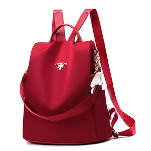 Mochila de tela Oxford roja impermeable con logo dorado y colgante de oso