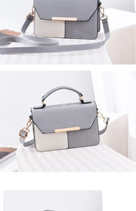 Détail du sac bandoulière élégant bicolore avec boucle dorée et coutures géométriques