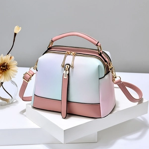 Pink and mint green gradient PU leather handbag with gold zippers and adjustable shoulder strap