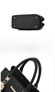 Detail view of black lychee leather bag bottom with golden feet and handle hardware
