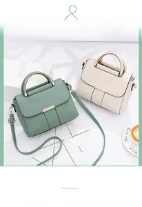 Detail of sage green and off-white faux leather handbags with gold metal hardware and strap