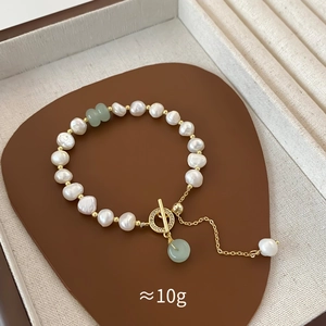 Detail of baroque freshwater pearl bracelet with green beads and gold OT clasp