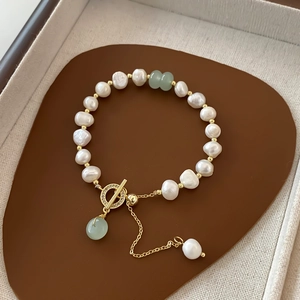Detailed shot of baroque pearl bracelet with green gemstone and gold-plated OT clasp