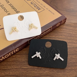 Detailansicht der verknoteten Pavé-Zirkonia-Ohrringe in Gold- und Silber-Finish