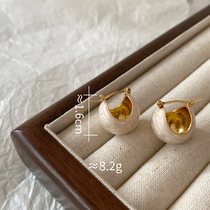 Detail of cream enamel hoop earrings with gold plating and size dimensions in a jewelry box