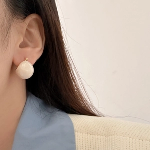French vintage round cream enamel bead earrings with gold-plated copper hooks on a model