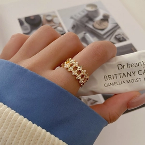 Elegant gold flower ring with pearls and zircons shown in a lifestyle setting