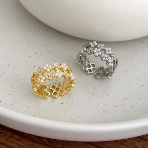 Detail of floral hollow rings with zircon and pearls in gold and silver plating
