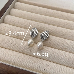 Détail de boucles d'oreilles coquillage avec perles et dimensions sur velours