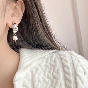 Boucles d'oreilles élégantes torsadées argentées avec perles d'eau douce sur mannequin